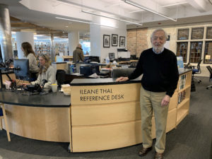Bruce Thal stands at desk