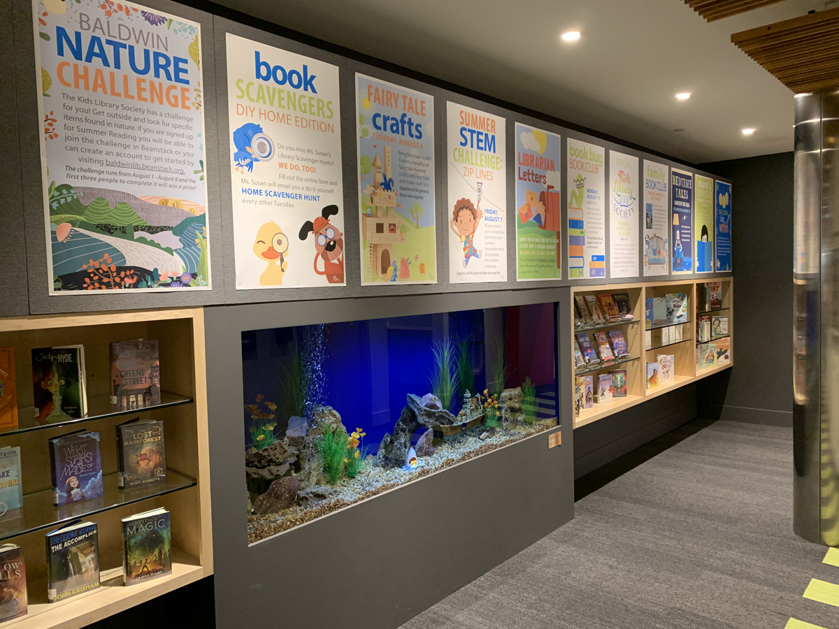 The entry hallway to the Youth Room includes an 8-foot aquarium, book display shelving, and poster boards to advertise upcoming programs.