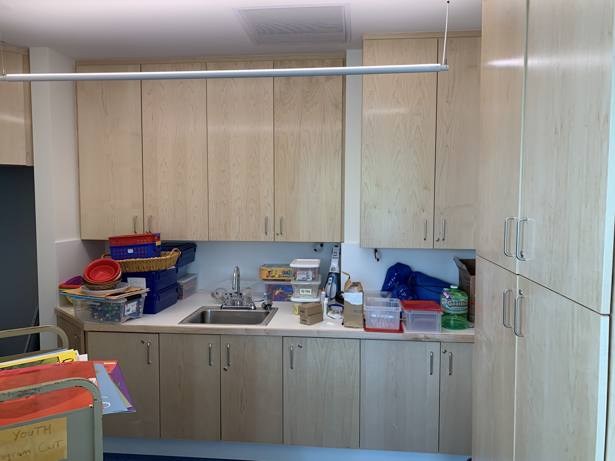 Grams Discovery Room includes a small workspace with a sink, work counter, and cabinets for materials storage.