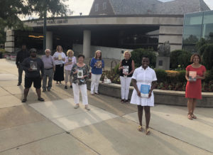 Friends Board members standing outside the library holding books