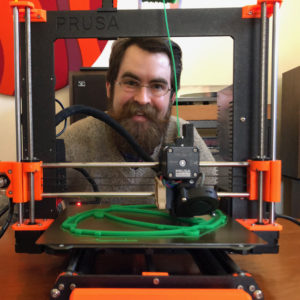 Jeff Jimison poses behind 3d printer