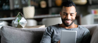 Man sitting on a couch with a digital tablet