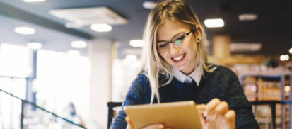 Woman wearing glasses scrolling on a digital tablet