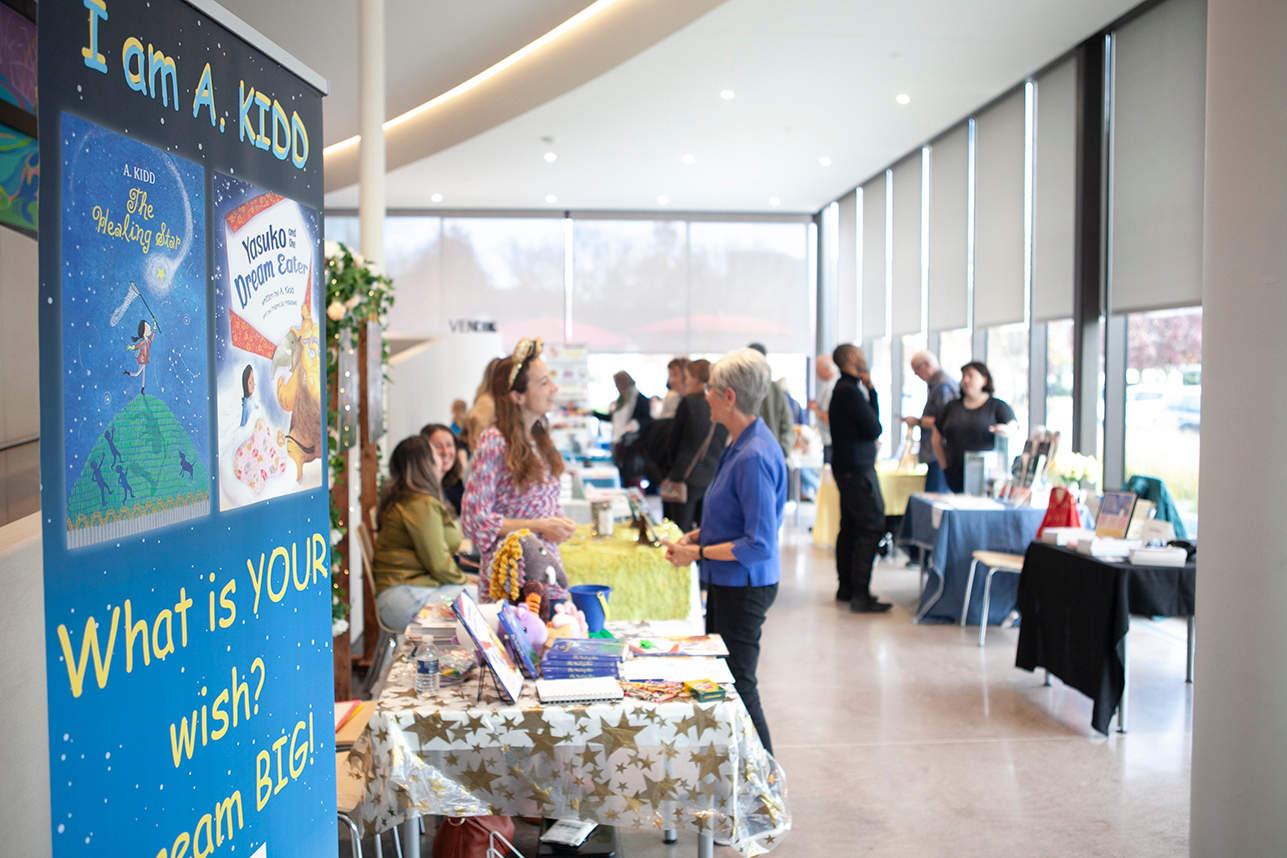 People standing at the tables of authors looking at books