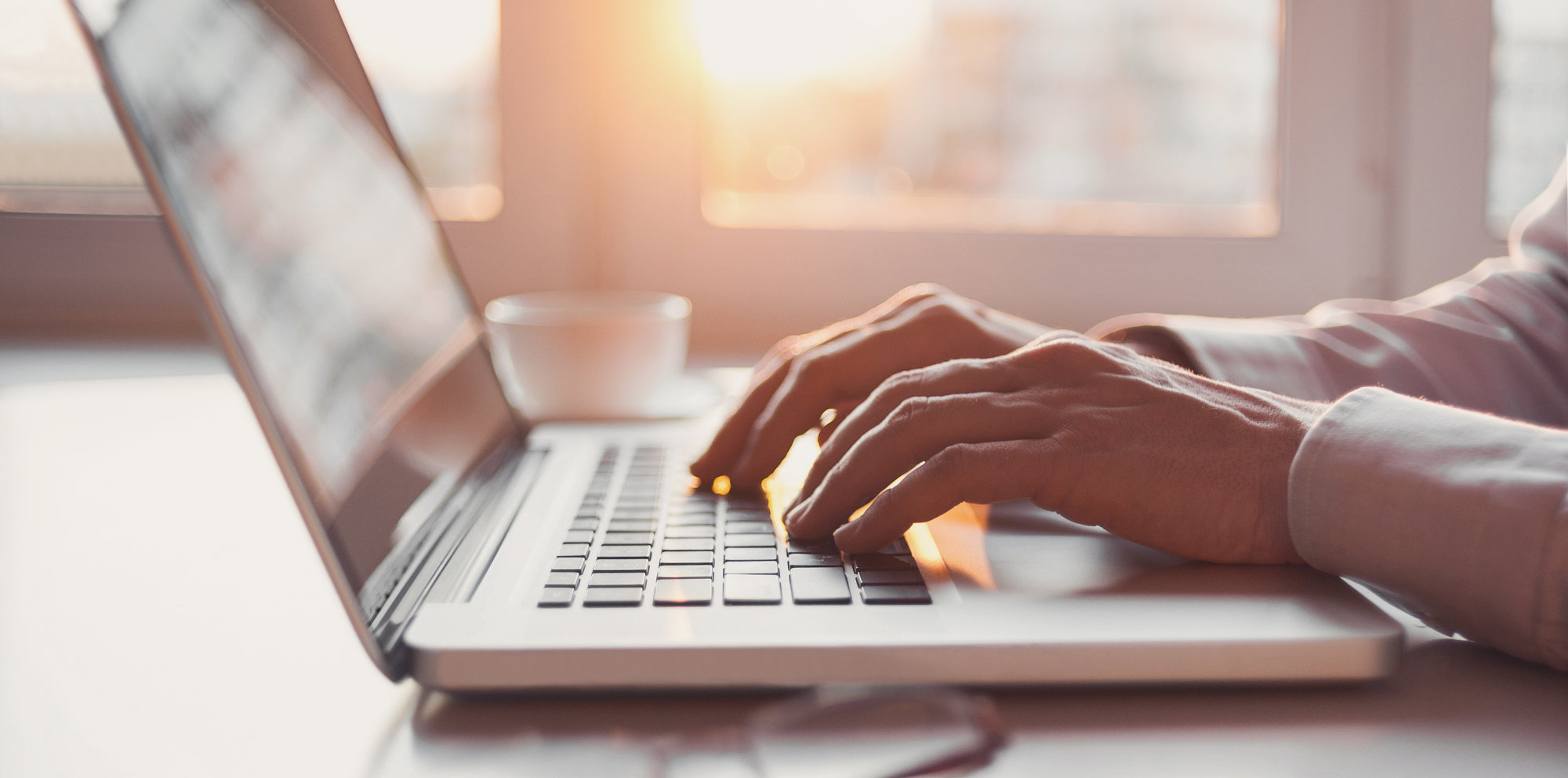 Hands resting on the keys of a laptop computer.